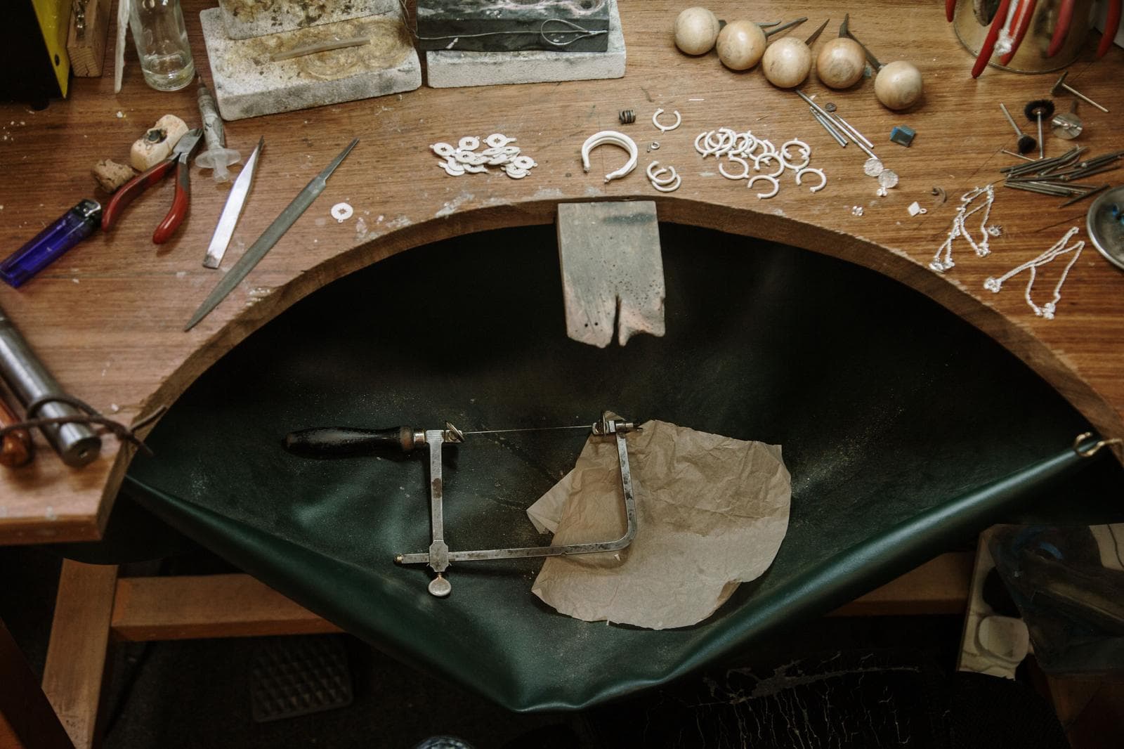 A goldsmith's workbench — piercing saw on the bench peg, files and silver findings laid out